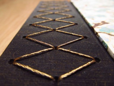 A close-up of the book's gold stitching.