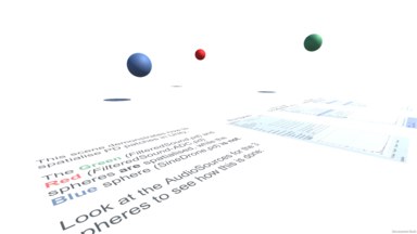 A screenshot of the example project, with 3 differently-coloured spheres representing individual sound sources, and explanatory text on the ground.