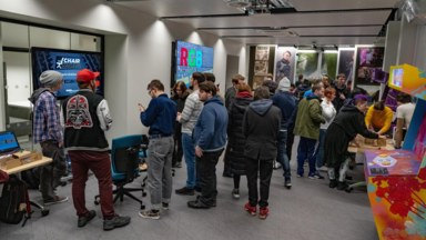 Photograph from the Jam showcase. A lot of people standing around, playing games, chatting etc. in the SDI exhibition space.