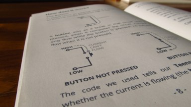 A photograph of page 8 of the physical zine, explaining how buttons work (electrically).
