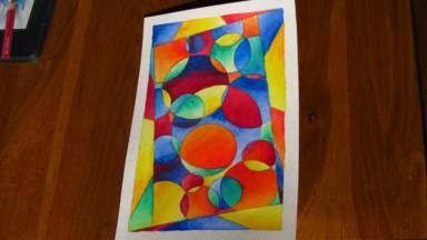 A painting with multiple brightly-coloured overlapping circles within an angled rectangular frame.